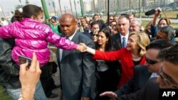 Ngoại trưởng Hoa Kỳ Hillary Clinton bắt tay với 1 đứa bé khi đi thăm quảng trường Tahrir tại Cairo, Ai Cập, 16/03/2011